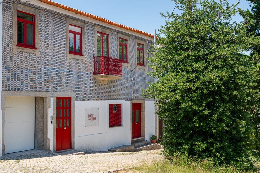 Fachada de azulejo com janelas vermelhas