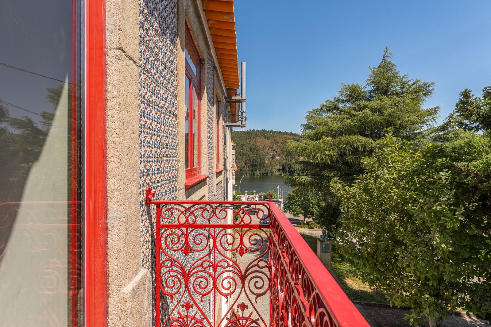 Varanda de ferro vermelha do Douro Arda House, com o rio Douro ao fundo