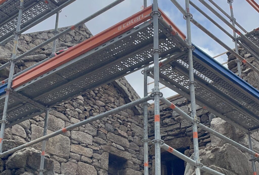 Andaimes sobre as paredes de granito de uma casa em obra