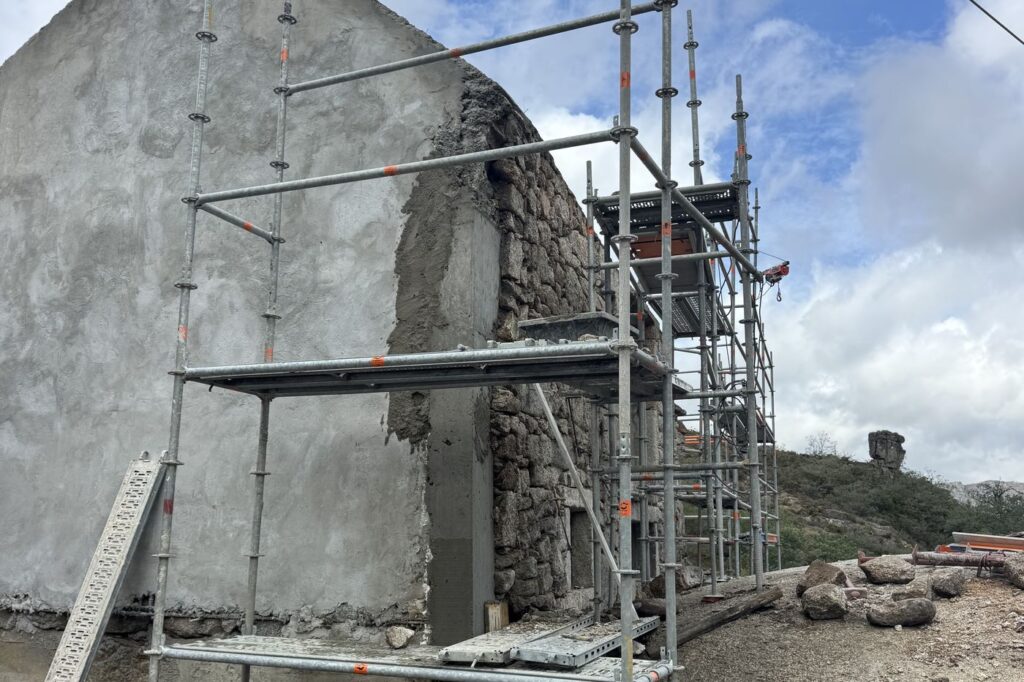 Empena rebocada e pedra à vista, com o andaime montado