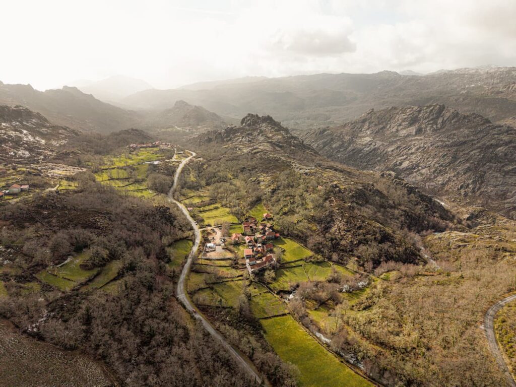 Vista aérea do Fundo da Aldeia, com casas de telhado vermelho entre as montanhas