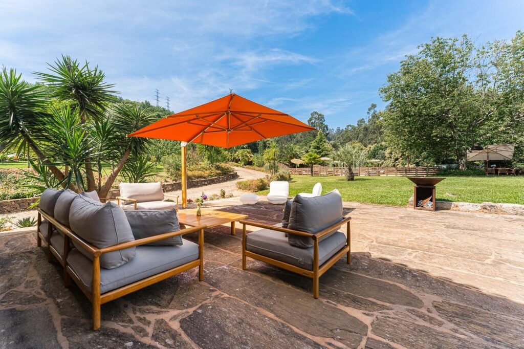 Sofás de exterior e guarda-sol laranja no terraço