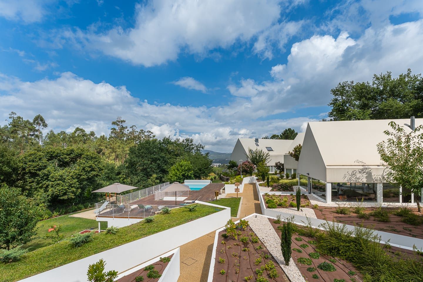 As villas, a piscina e o vale vistos do alto da propriedade